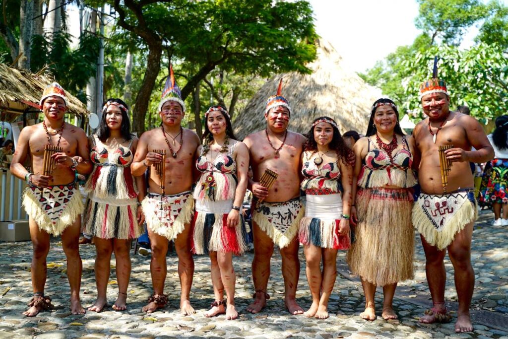 Varios indígenas posan con trajes típicos durante los actos previos a la inauguración de la Zona Verde en la COP16.