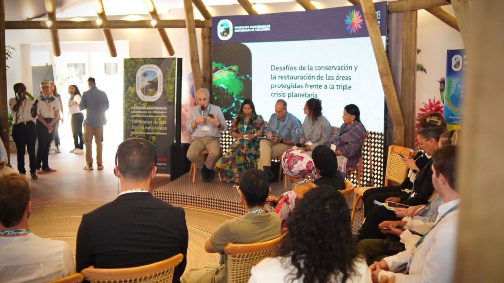 Varias personas, sentadas, asisten a una conferencia durante la inauguración del Pabellón Colombia en la COP16.