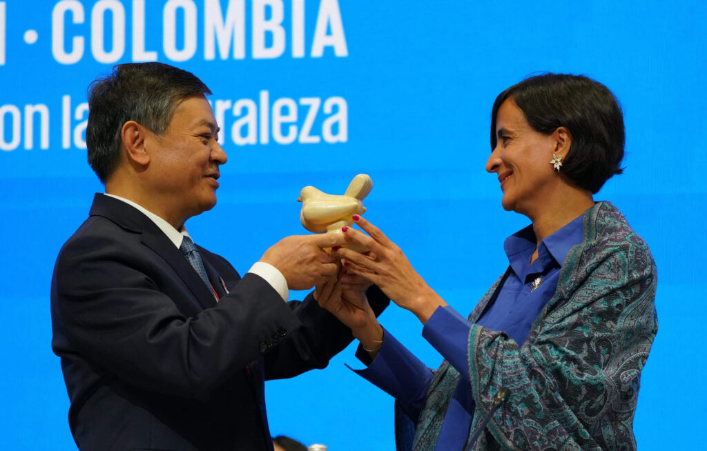 El ministro de Ecología y Medio Ambiente de China, Huang Runqiu entrega la presidencia de la COP de Biodiversidad a la ministra de Ambiente, Susana Muhamad, durante la apertura de la COP16.